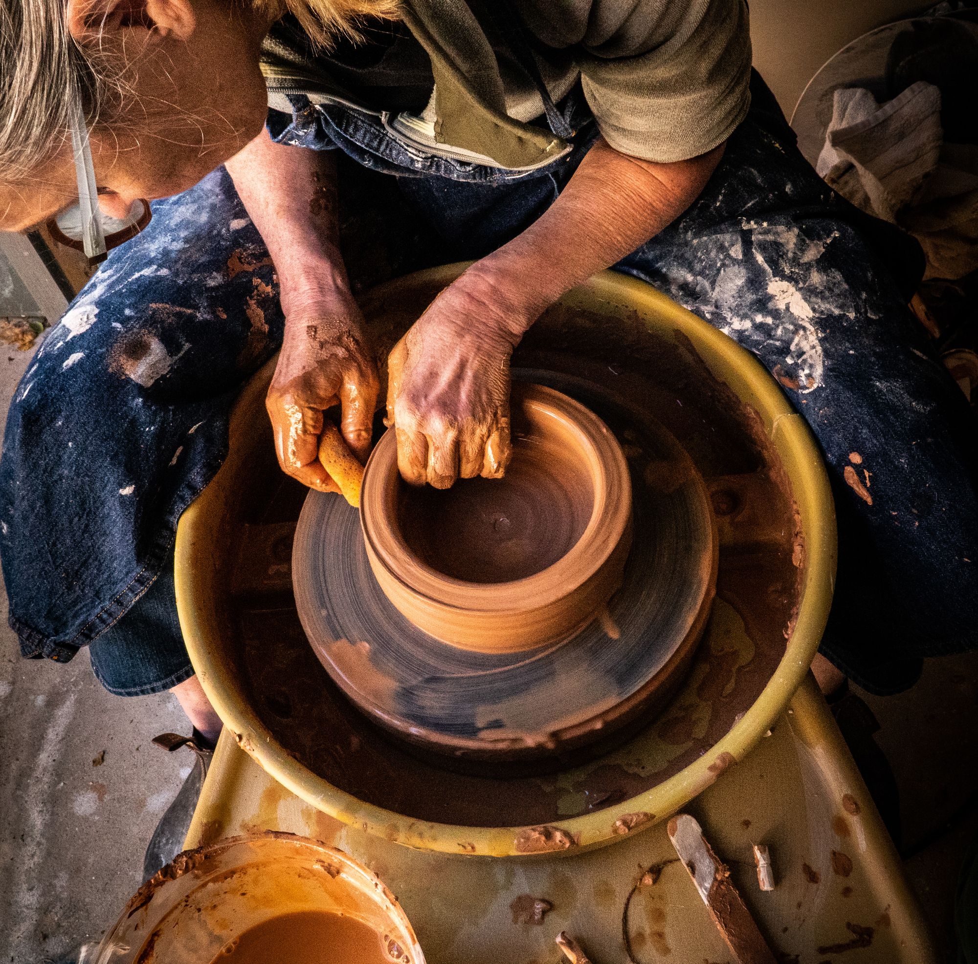 Image of a potter making a bowl on a pottery wheel