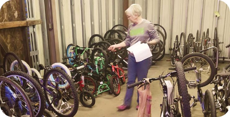 A woman takes inventory of the bike donations and adds labels with the repair status.