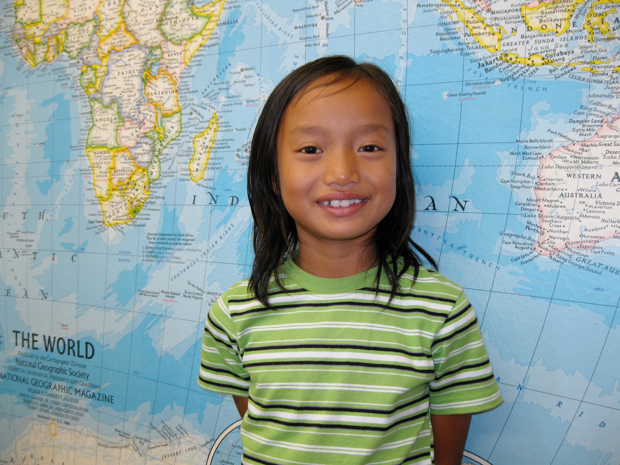 Child standing in front of a world map