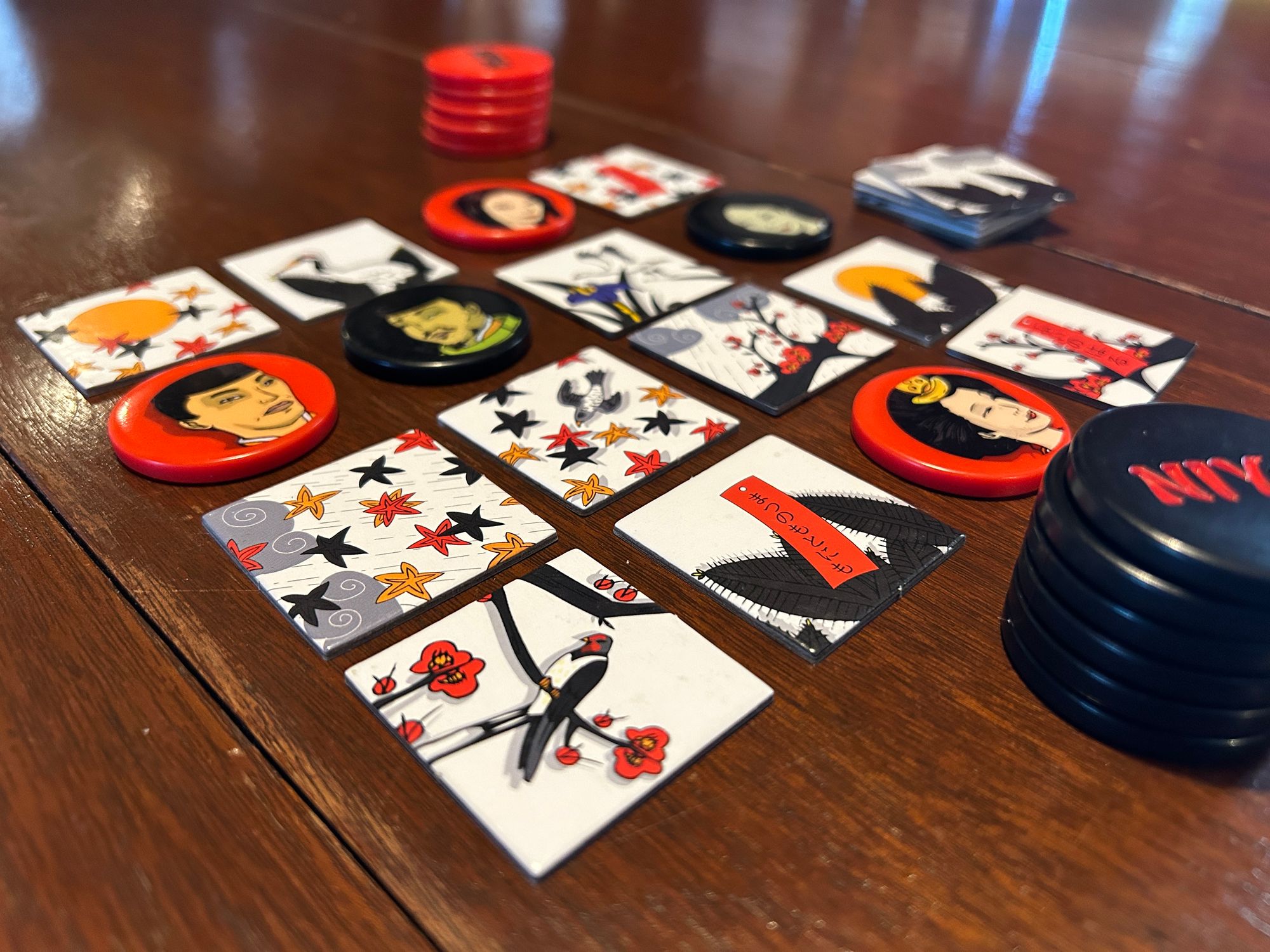 Tile grid with tiles and discs from the game Niya on a wooden table