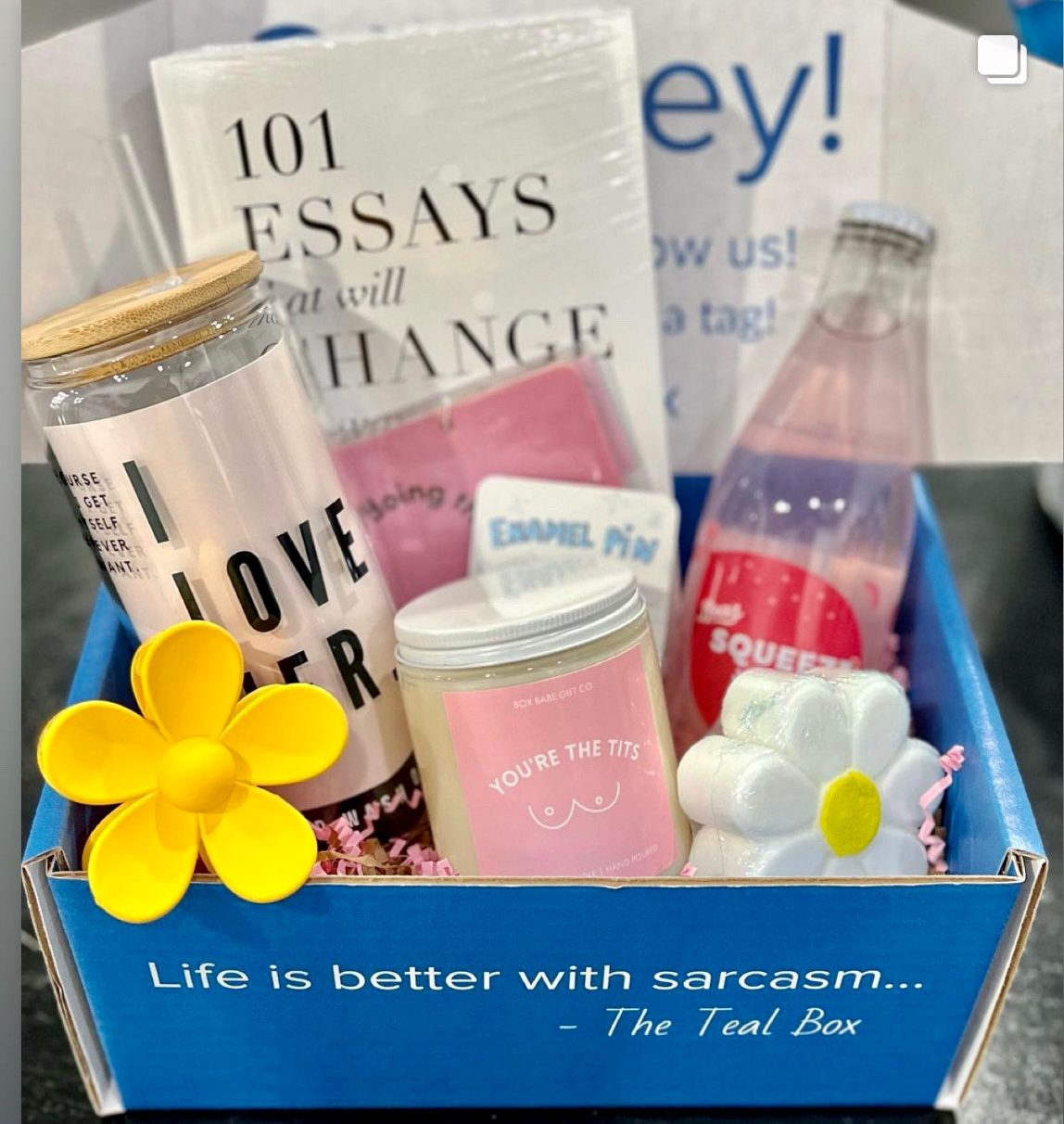A gift box full of a variety of items that reads: "Life is better with sarcasm. —The Teal Box"