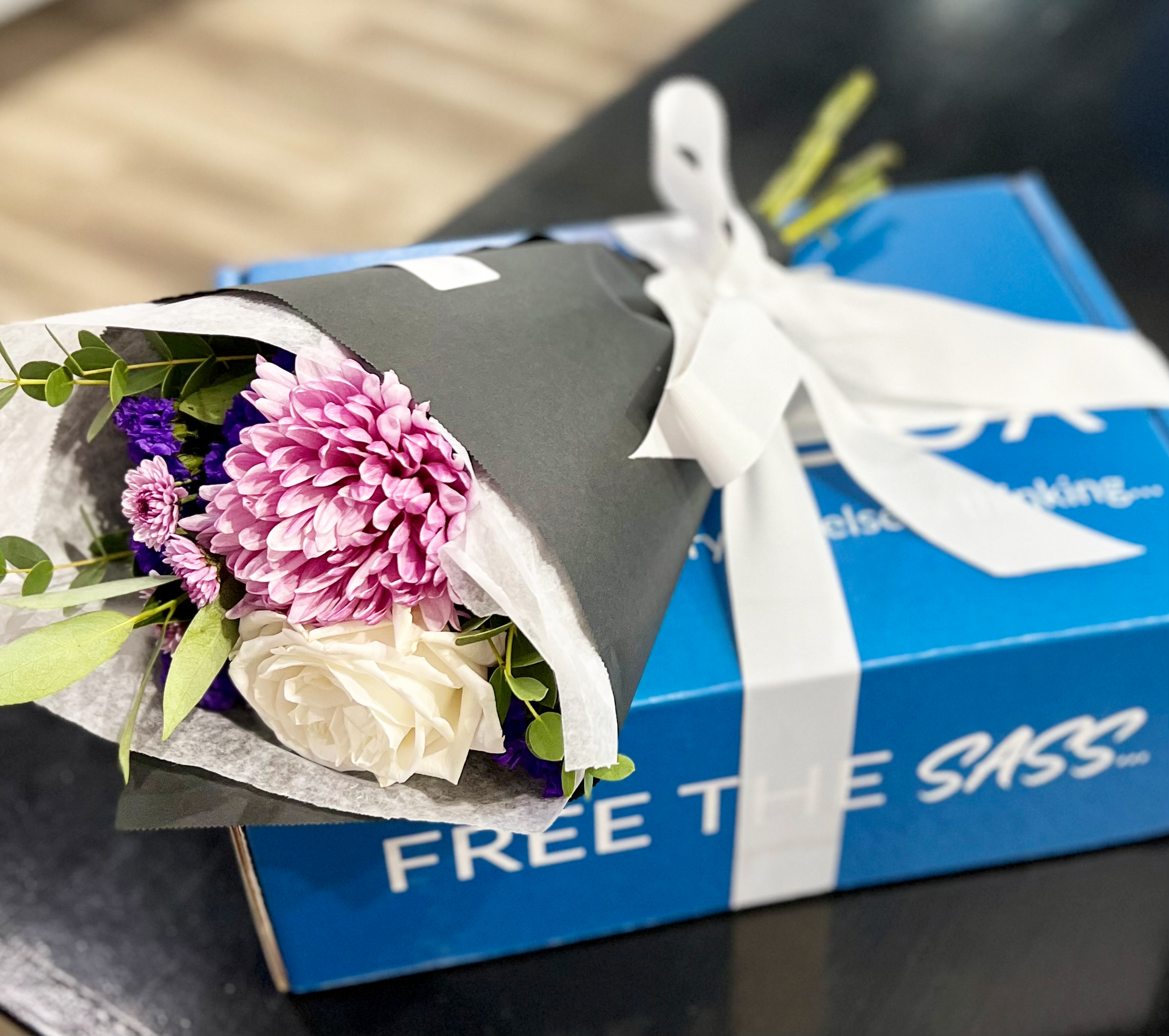 A bouquet of flowers on a small teal box
