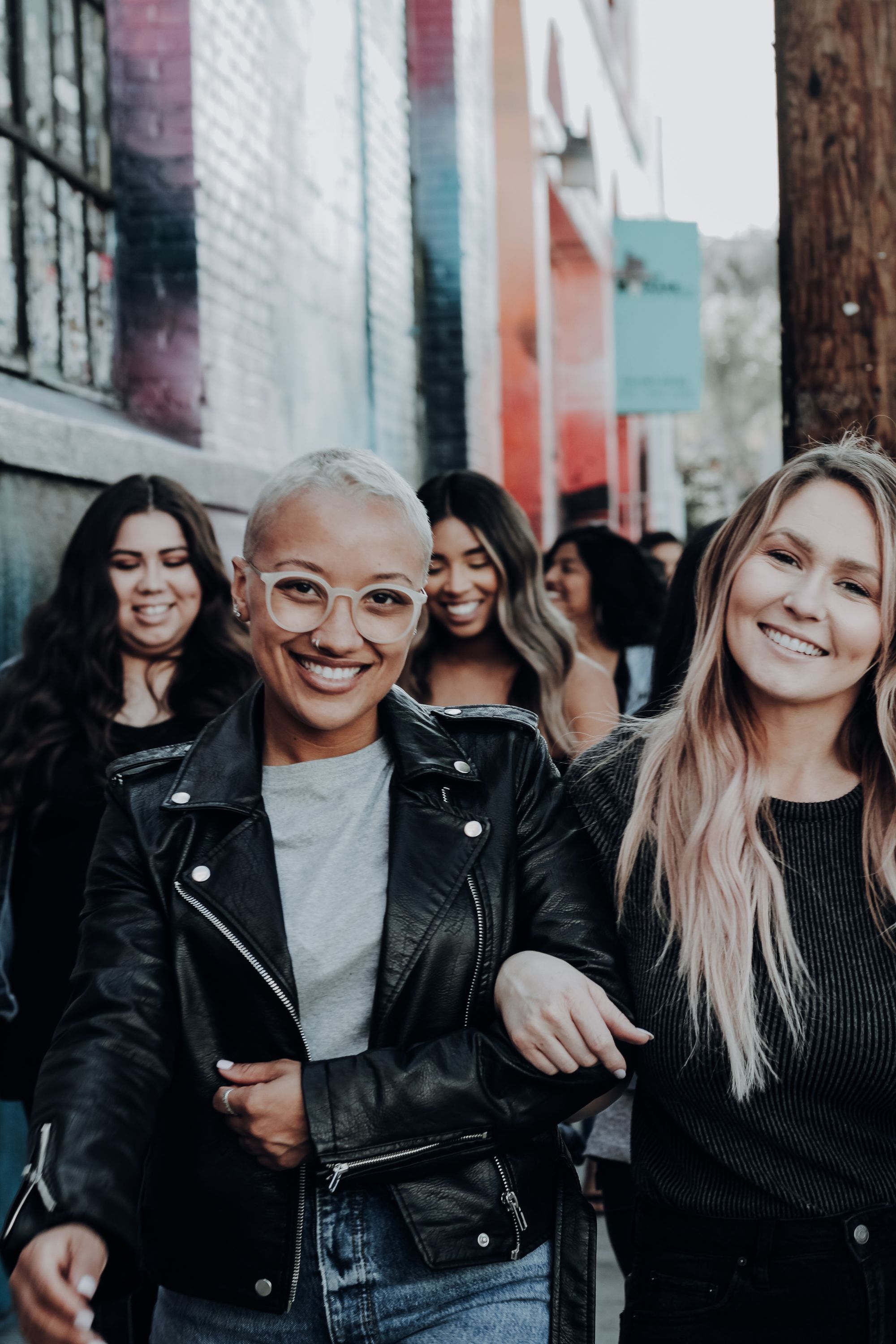 Photo of a group of friends walking together, some arm-in-arm