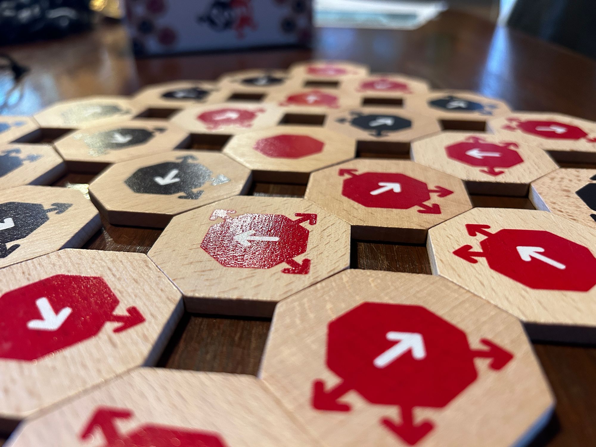 An image of a hexagonal tile board game decorated with arrows facing different directions.