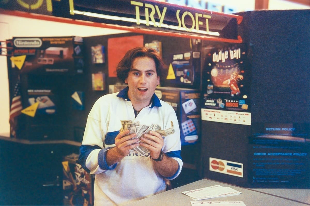 An image of John Reed holding a bunch of dollar bills.