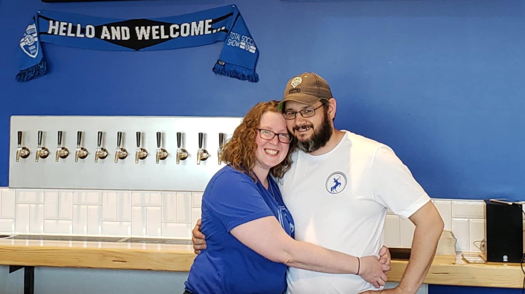 An image of two people hugging and smiling at the camera.